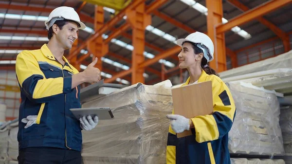 Industrial worker man in uniform show thumbs up appreciate the work of woman worker at manufacturing factory