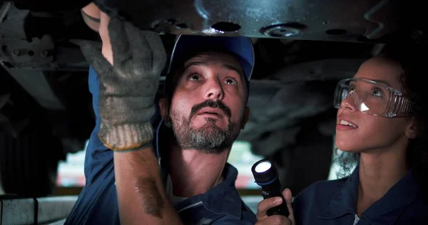 Dwóch Mechaników Naprawia Zawieszenie Podnoszonego Samochodu Doświadczony Technik Serwisu Samochodowego — Zdjęcie stockowe