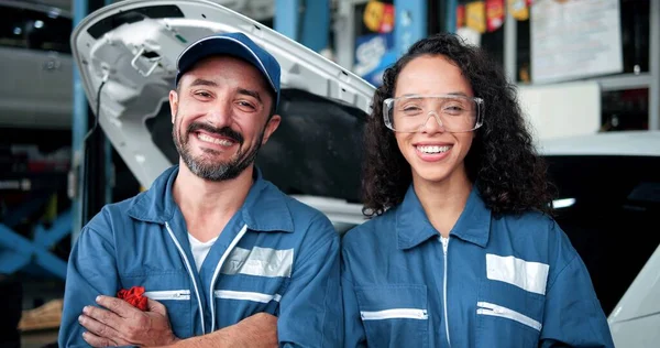 2台の笑みを浮かべて車の整備士がガレージでカメラを見て立って 自動車の前で均一で技術者の肖像画 修理車チームサービスの概念 — ストック写真