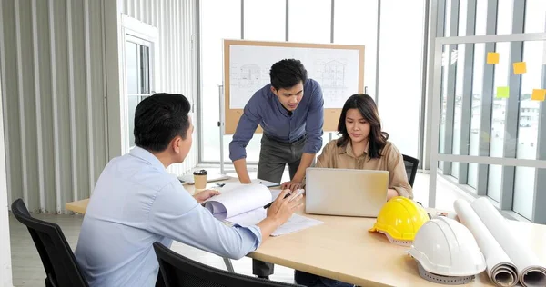アジアグループ建築家オフィスのビジネス会議室で青写真で計画に取り組む建築家 ビジネス計画を議論する建築家 — ストック写真