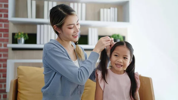 Счастливая Любящая Семья Азиатская Мать Расчесывает Волосы Своей Дочери Сидя — стоковое фото
