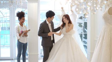 Damat takımı ve Asyalı güzel gelin düğün töreni için gelinlik seçiyor.