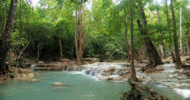 Tatil için temiz zümrüt suyu Erawan Şelalesi 'nde yeşil orman veya ormanda seyahat Kanchanaburi, Tayland' daki Erawan Ulusal Parkı 'nda