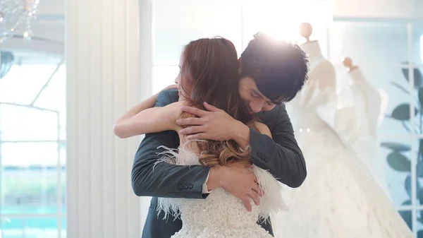 アジアの新郎のスーツと白いウェディングドレスの美しい花嫁は一緒に結婚式のスタジオで抱擁 — ストック写真