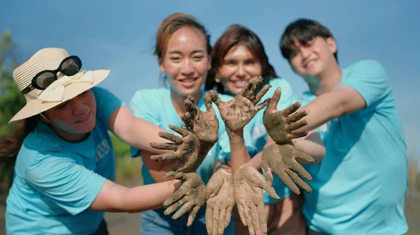 Grupo Voluntarios Asiáticos Mostrando Las Manos Manchadas Signo Barro Sonriendo — Foto de Stock