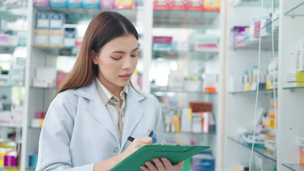 Profesjonalna Azjatka Farmaceutka Ponownie Sprawdza Produkty Aptece Używa Notatnika Pisania — Zdjęcie stockowe