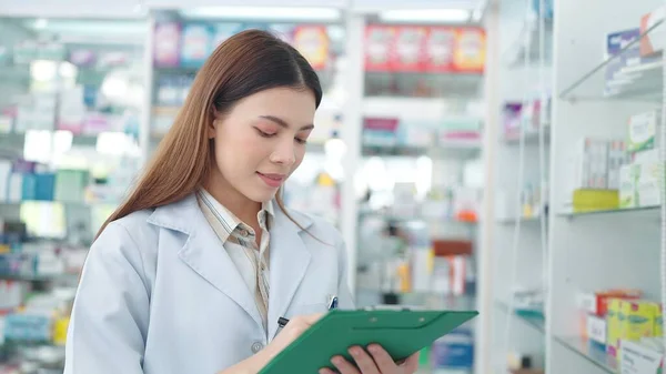 Επαγγελματική Ασιατική Γυναίκα Φαρμακοποιός Επανεξετάζει Προϊόντα Στο Φαρμακείο Και Χρησιμοποιώντας — Φωτογραφία Αρχείου