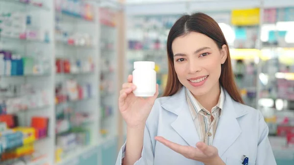 Professionelle Asiatische Apothekerin Lächelt Selbstbewusst Und Hält Eine Tablettenschachtel Der — Stockfoto
