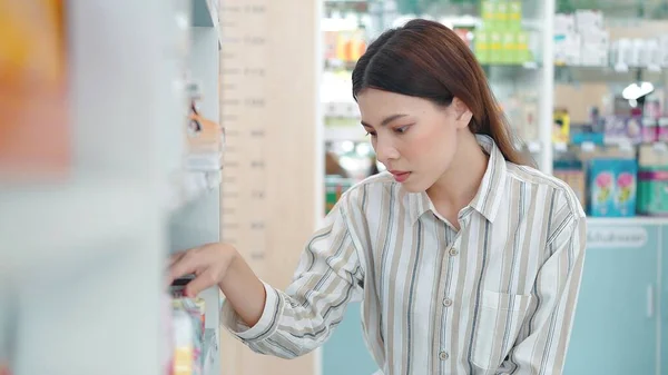 Piękna Młoda Azjatycka Kobieta Stojąca Między Półkami Szukając Kupując Leki — Zdjęcie stockowe