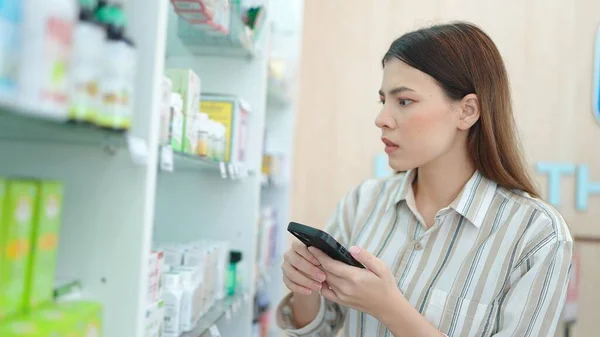 Beautiful Young Asian Woman Holding Smartphone Looking Shopping Medicine Supplements — Stock Photo, Image