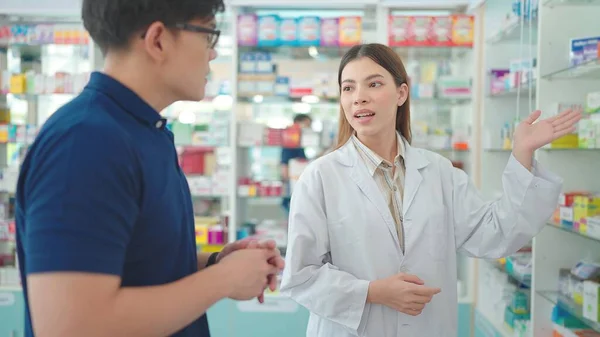 Asiatische Apothekerin Empfiehlt Und Erklärt Kunden Der Apotheke Ein Medikament — Stockfoto