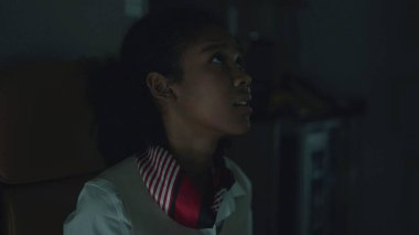 Afrika kökenli Amerikalı hostes, uçuş görevlisi koltukta paniklemiş ve fırtına türbülansında uçmaktan endişe ediyor.