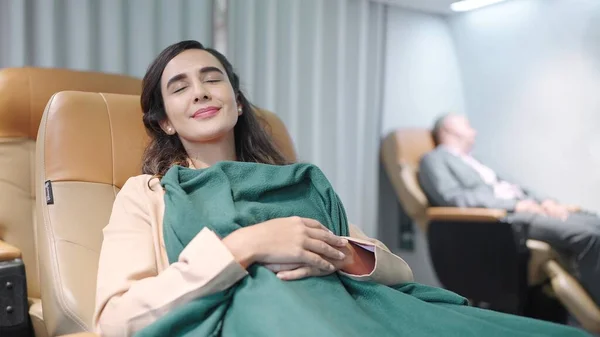 飛行機で旅行している間 若いヒスパニック系ラテン系の女性の乗客が毛布で座席で寝ています 長い飛行中の女性の旅行 — ストック写真