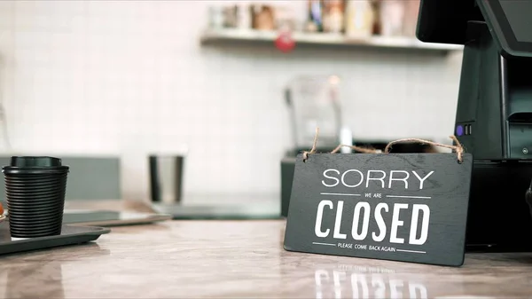 Sorry closed sign on counter at coffee shop, cafe. Closed sign board on the bar counter in an empty coffee shop. Small business concept