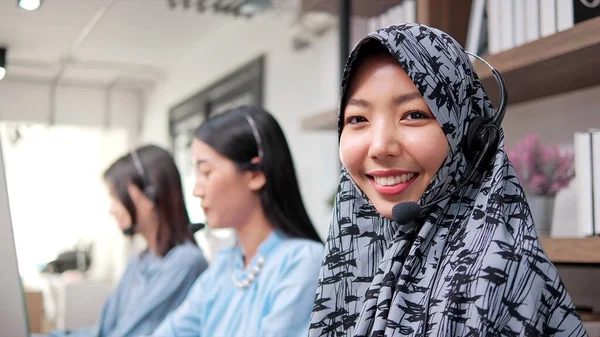 ポートレートクローズアップ笑顔顔のイスラム教徒の女性身に着けていますヒジャーブとともにヘッドフォンで作業コールセンターで見ますカメラ — ストック写真
