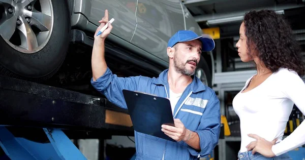 Automotive Mechanik Mężczyzna Mundurze Wyjaśniając Listę Kontrolną Konserwacji Samochodów Naprawy — Zdjęcie stockowe