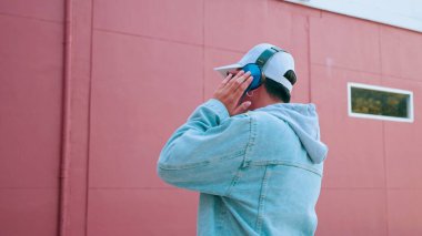 Kot pantolon giyen, kulaklık takan, müzik dinleyen ve en sevdiği şarkıyı seven Asyalı genç adam. Yaşam tarzı ve mutluluk kavramı