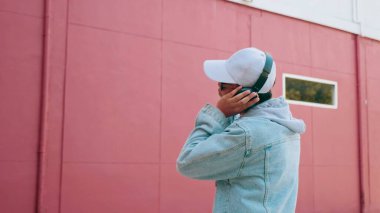 Kot pantolon giyen, kulaklık takan, müzik dinleyen ve en sevdiği şarkıyı seven Asyalı genç adam. Yaşam tarzı ve mutluluk kavramı