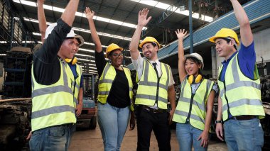 Profesyonel makine mühendisi ekibi. Başarılı çalışanlar eski otomobil parçaları deposunda kutlama yapıyorlar. Takım el ele tutuşuyor. Birlik ve takım çalışması kavramı