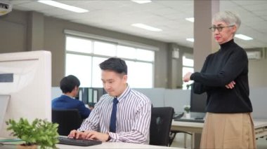 Asyalı ciddi bir adam dizüstü bilgisayarda baskı altında daktilo yazarken patronlarının onları tam bir iş yapmaya zorladığını söyledi..