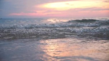 Gün batımında okyanus yüzeyindeki dalgaların süper yavaş çekimi, yakın çekim günbatımı tatil arkaplanı.