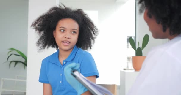 Afrykanka Lekarz Pediatra Rozmawia Nastolatką Pacjent Robi Notatki Tablicy Wyjaśniające — Wideo stockowe