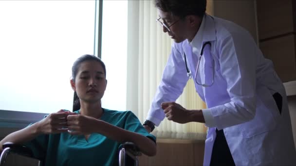 アジアの医師は 病院病棟で診察を受けながら 車椅子に座って真剣に患者さんと話をしました 悪い知らせ悪い結果で患者は不幸になる — ストック動画