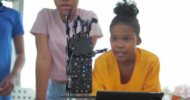 アフリカ系黒人の子供たちのグループはロボットアームスクールについて学び 教師はロボット工学教室の小学生を支援している テクノロジーとイノベーションの概念 — ストック動画