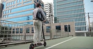 İş için elektrikli scooter kullanan Asya işi şehir merkezinde işe gider. Ekolojik ulaşım kavramı