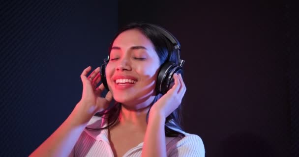 Glückliche Frau Hört Studio Mit Neonlicht Musik Über Kopfhörer — Stockvideo