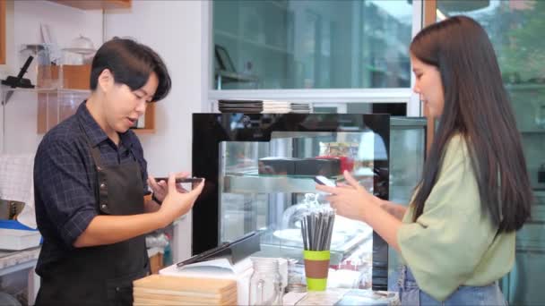 通过智能手机扫描咖啡店或餐馆里另一个智能手机上的Qr代码标签 亚洲女性顾客和咖啡师可以免费获得数字支付 — 图库视频影像