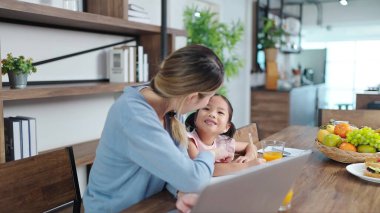 Asyalı anne küçük kızına evde ödev yapmayı öğretiyor. Anne, kızına ev ödevi yaparken yardım ediyor. Bekar anne, anne ve çocuk ilişkisi kavramı