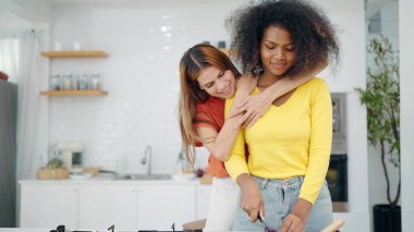 Mutlu lezbiyen çift, evdeki mutfak odasında birlikte yemek pişirirken birbirlerine sarılıyorlar. Lezbiyen çift mutfak odasında sarılıyor. Lgbt ilişki kavramı
