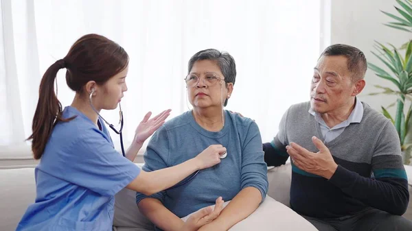 アジアの女性看護師は 成熟した中年女性患者の心拍と肺をチェックするステススコープを使用しています 介護サービスや高齢者向け心臓病医療 高齢者ケアコンセプト — ストック写真