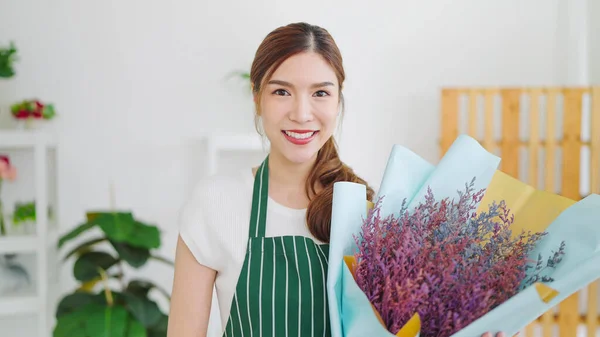 美丽的亚洲女人的画像 拥有花店 手持花束 对着相机微笑 女花匠拿着一束鲜花站在花店旁 小企业概念 — 图库照片