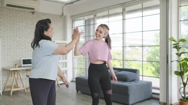 stock image Happy Asian elderly woman and daughter give high five before doing exercise together. Elderly lifestyle, Family activity concept