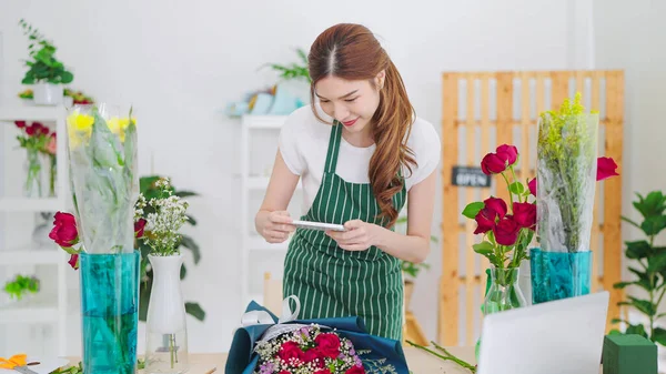 Akıllı Telefon Kullanan Asyalı Genç Bayan Çiçekçi Müşteriye Bir Buket — Stok fotoğraf