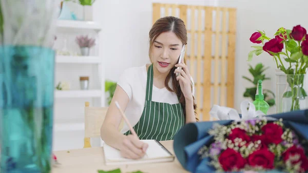 Önlüklü Güzel Asyalı Kadın Çiçekçi Akıllı Telefondan Konuşuyor Müşteriyle Sipariş — Stok fotoğraf