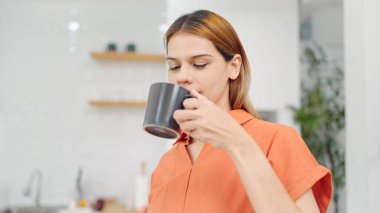 Yaşam tarzı konsepti. Rüyasında genç bir kadın sabahları evde çay ya da kahve içerek eğleniyor. Kahvaltının tadını çıkaran bir kadın.