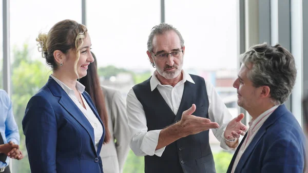 Caucasian man leader introducing woman manager to new team partner at seminar of company. Male leader introducing woman manager shaking hands welcoming newcomer