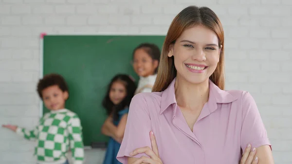 カメラを見ている白人小学生の女性教師の笑顔 学校のコンセプト 学習コンセプトに戻る — ストック写真