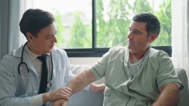 Νεαρός Γιατρός Μιλάει Και Επανεξετάζει Συμπτώματα Στον Ασθενή Μετά Θεραπεία — Αρχείο Βίντεο