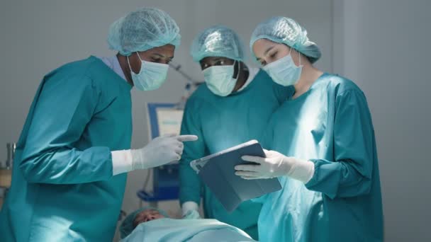 Profesjonalni Chirurdzy Asystenci Rozmawiają Korzystają Cyfrowych Tabletów Podczas Operacji Sali — Wideo stockowe