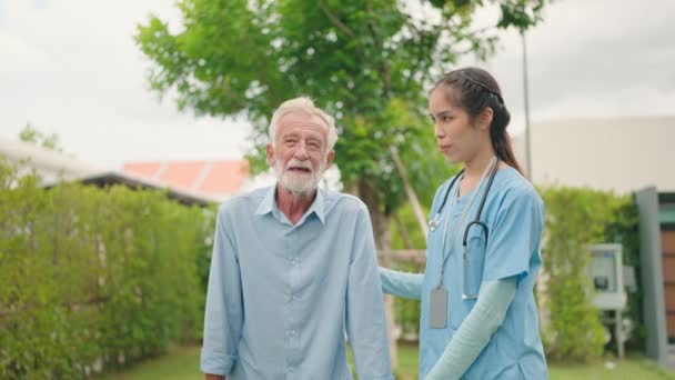女性看護師は アウトドアの緑のウォーカー 高齢者ヘルスケアコンセプトで上級男性を歩くのに役立ちます — ストック動画