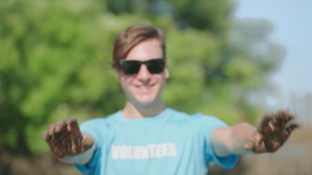 Voluntário Mostrando Mãos Sujas Sinal Lama Sorrindo Olhar Para Ajudantes — Vídeo de Stock