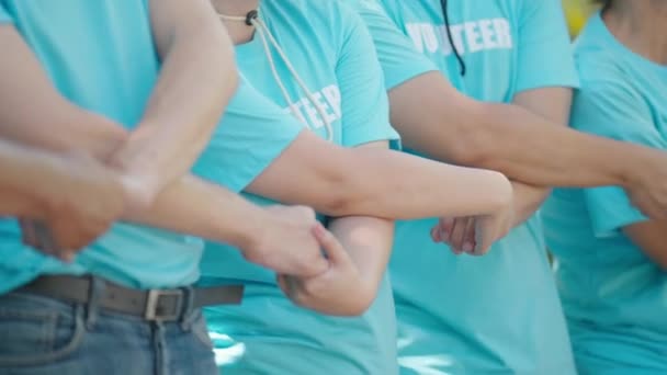 Διαφορετικοί Εθελοντές Που Κρατιούνται Χέρι Χέρι Στη Σειρά Μαζί Συνεργασία — Αρχείο Βίντεο