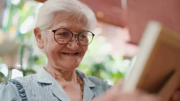 Asian elderly older grandmother looking family photographs while relaxing at home. Loving elderly older grandmother. Elderly older lifestyle, Aged people and relaxation concept