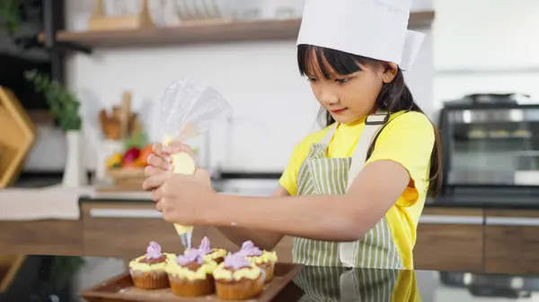 Önlüklü Küçük Asyalı Kız Çocuğu Aşçı Şapkalı Krem Şanti Yapımı — Stok fotoğraf