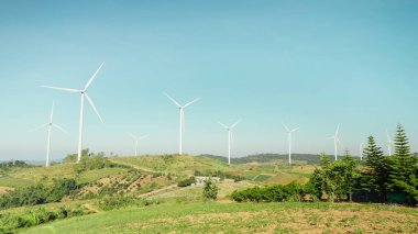 Güzel gökyüzü olan dağdaki yel değirmeni çiftliği. Rüzgar türbinleri elektrik üretir. Rüzgar enerjisi ve yeşil güç. Sürdürülebilir, yenilenebilir enerji. Yenilenebilir kaynak. Sürdürülebilir geliştirme