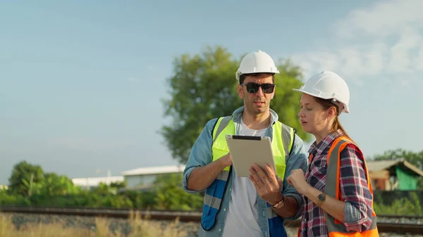 Doi Ingineri Uniformă Siguranță Cască Folosind Discuții Tablete Inspecții Construcția — Fotografie, imagine de stoc